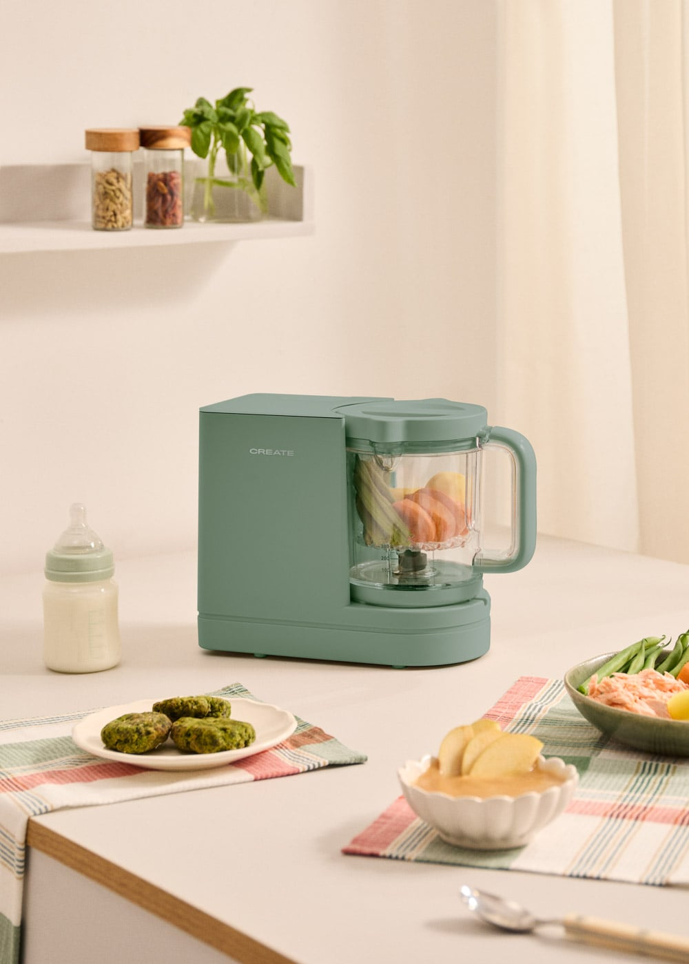 Procesador de alimentos verde con frutas y verduras. Comida para bebé en mesa.