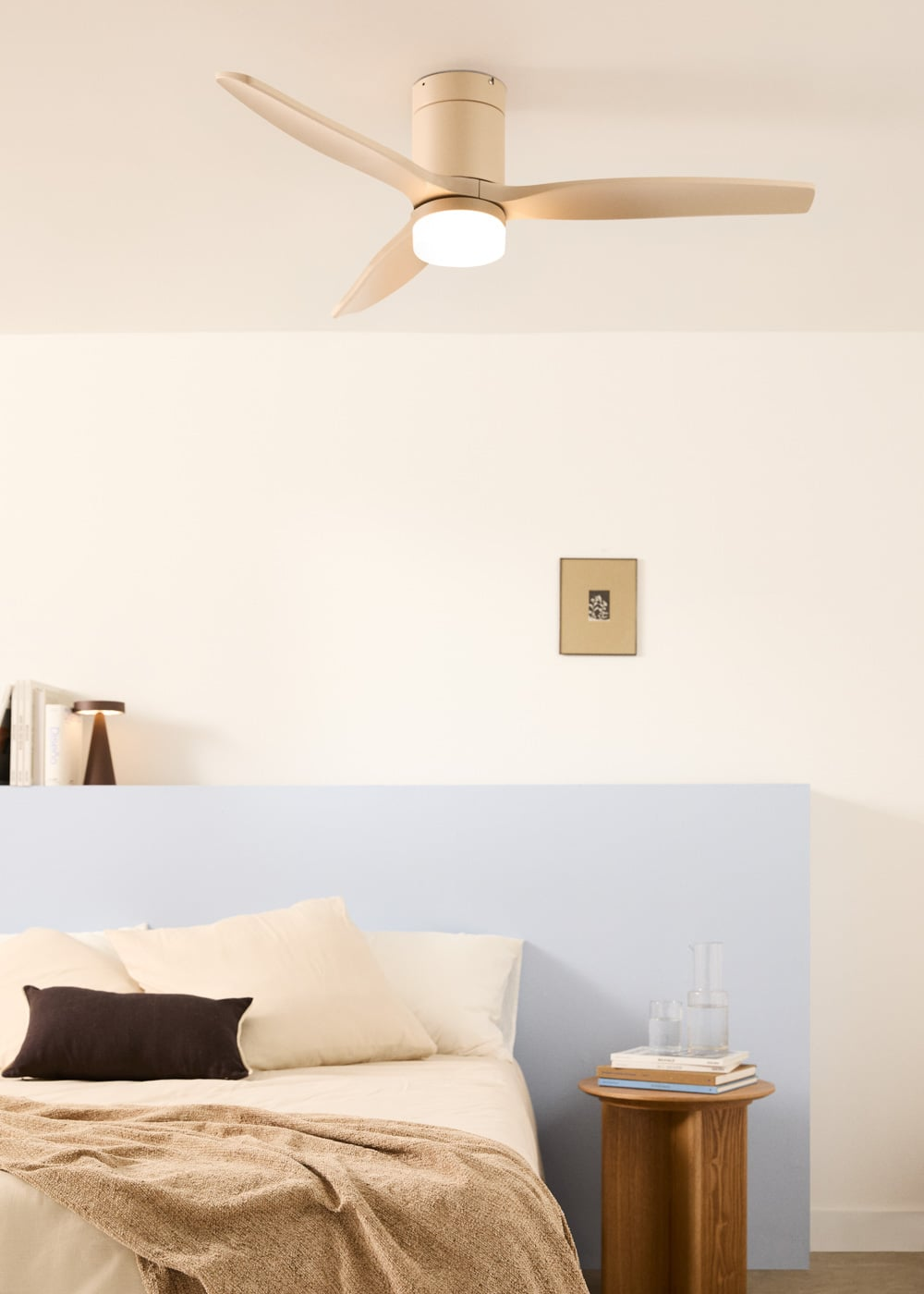 Un dormitorio moderno con ventilador de techo beige, cama y mesita de noche de madera.