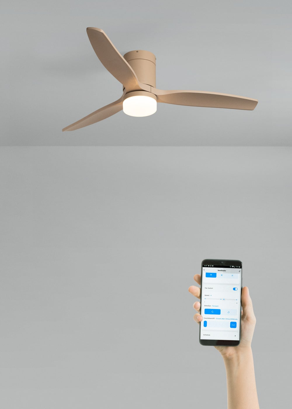 Un ventilador de techo color canela con luz sobre un smartphone que muestra una app.