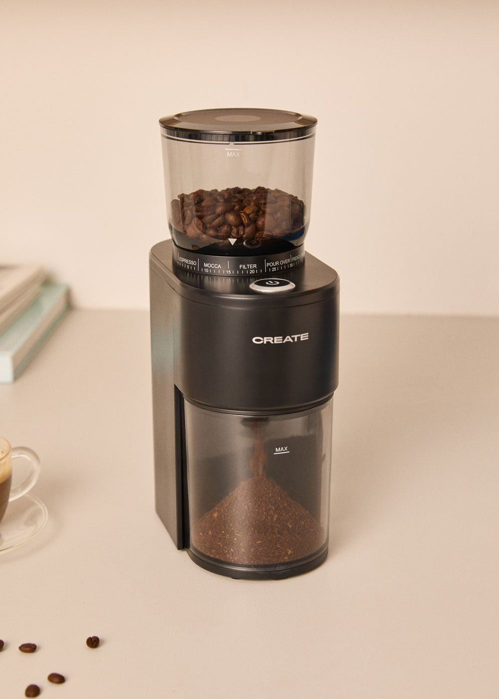 Un molinillo de café negro con granos arriba y café molido abajo.