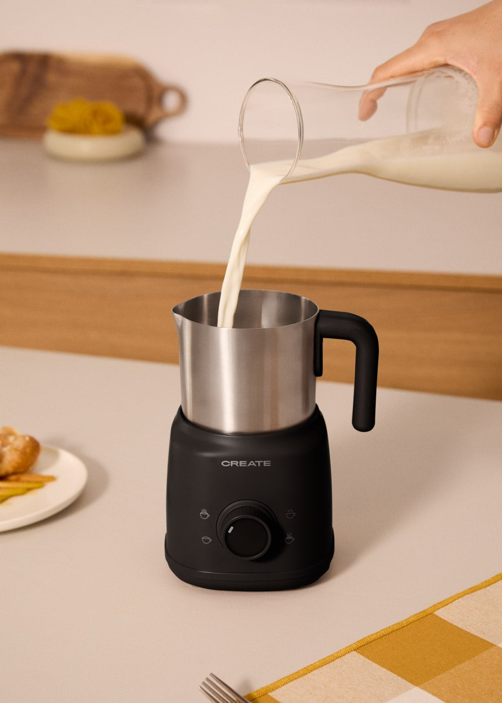 La leche se vierte de un vaso a un espumador de leche.