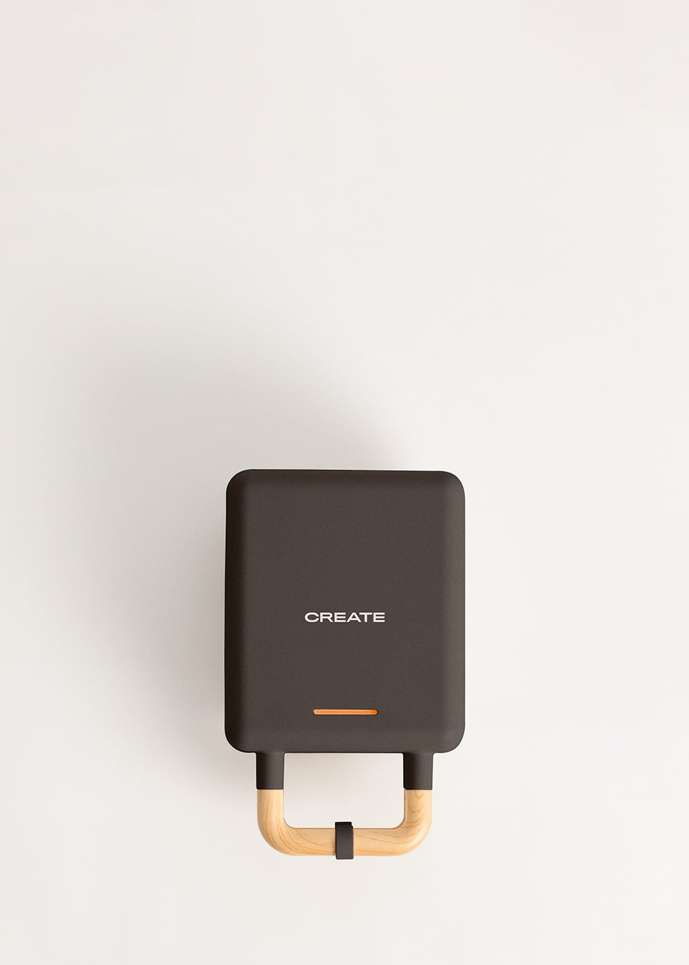 Máquina para hacer gofres oscura con mango de madera y luz naranja.