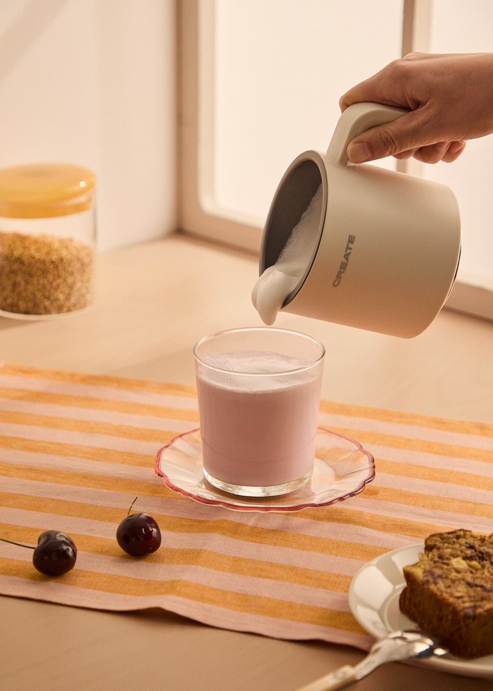 La espuma se vierte de una jarra a un vaso de líquido rosa.