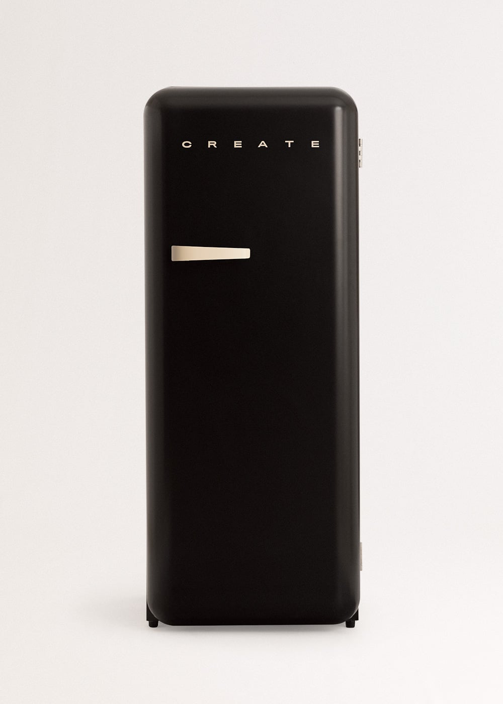 Un refrigerador negro vintage con la palabra CREATE sobre un asa color crema.