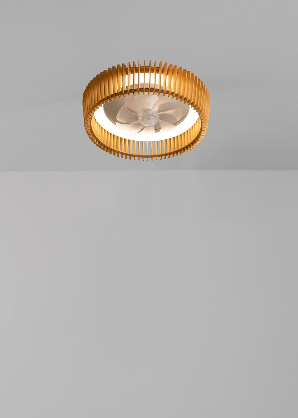 Un ventilador de techo con listones de madera e iluminación integrada.