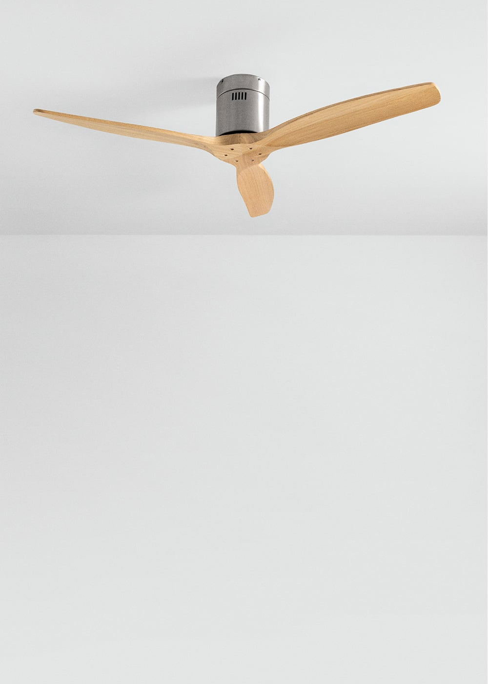 Un ventilador de techo moderno con tres aspas de madera y carcasa de metal gris.