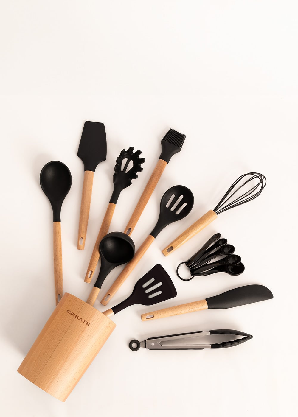Juego de utensilios de cocina con mangos de madera: cuchara, espátula, servidor de pasta, cucharón, batidor, medidores y pinzas.
