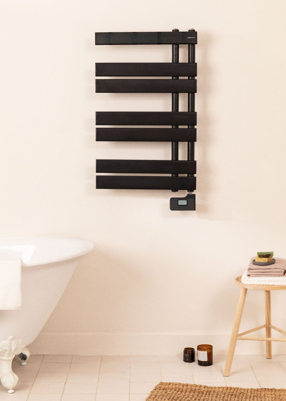 Un toallero negro sobre una bañera, con taburete y velas.