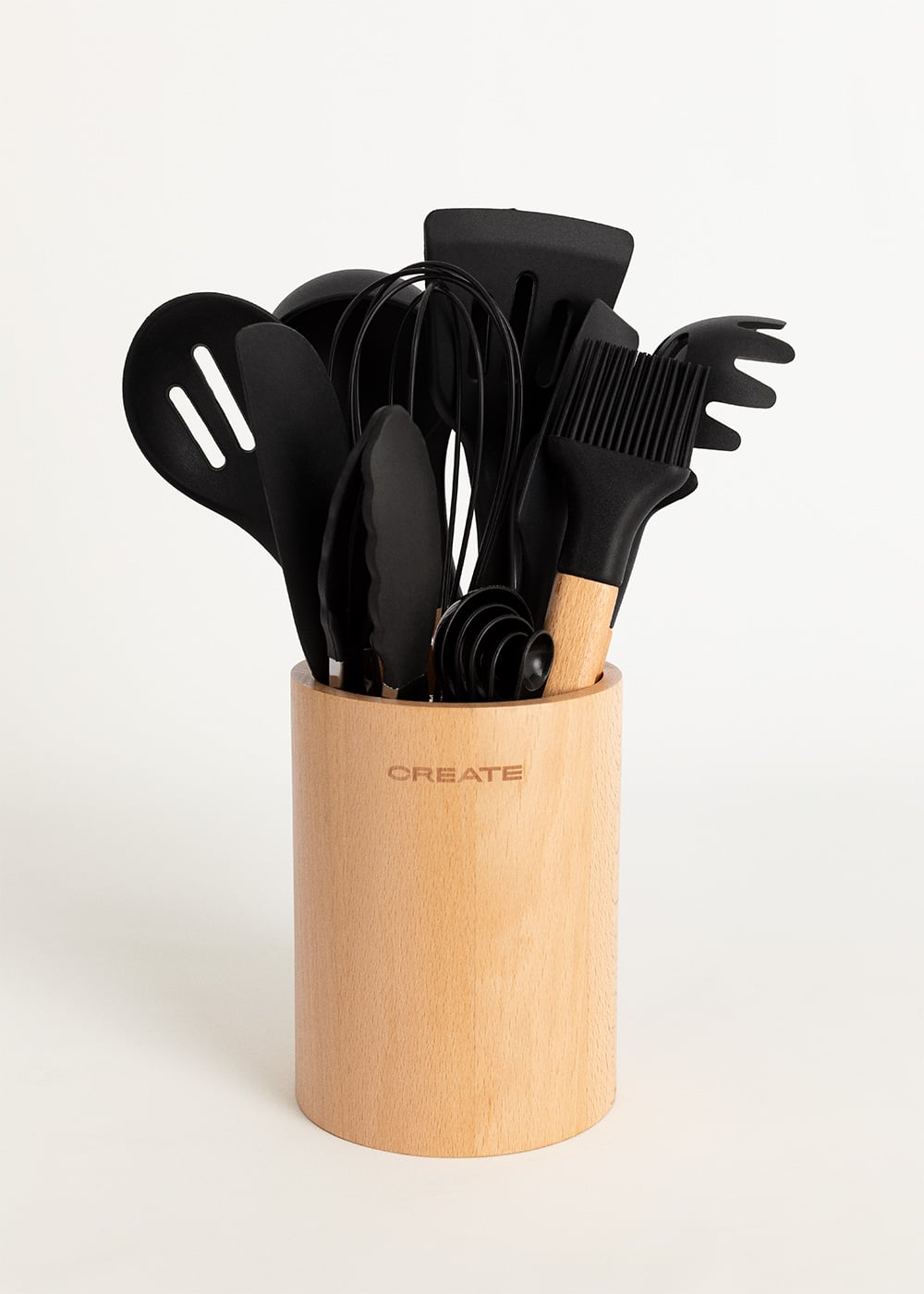 Set de utensilios de cocina negros en un soporte de madera con el logo CREATE.