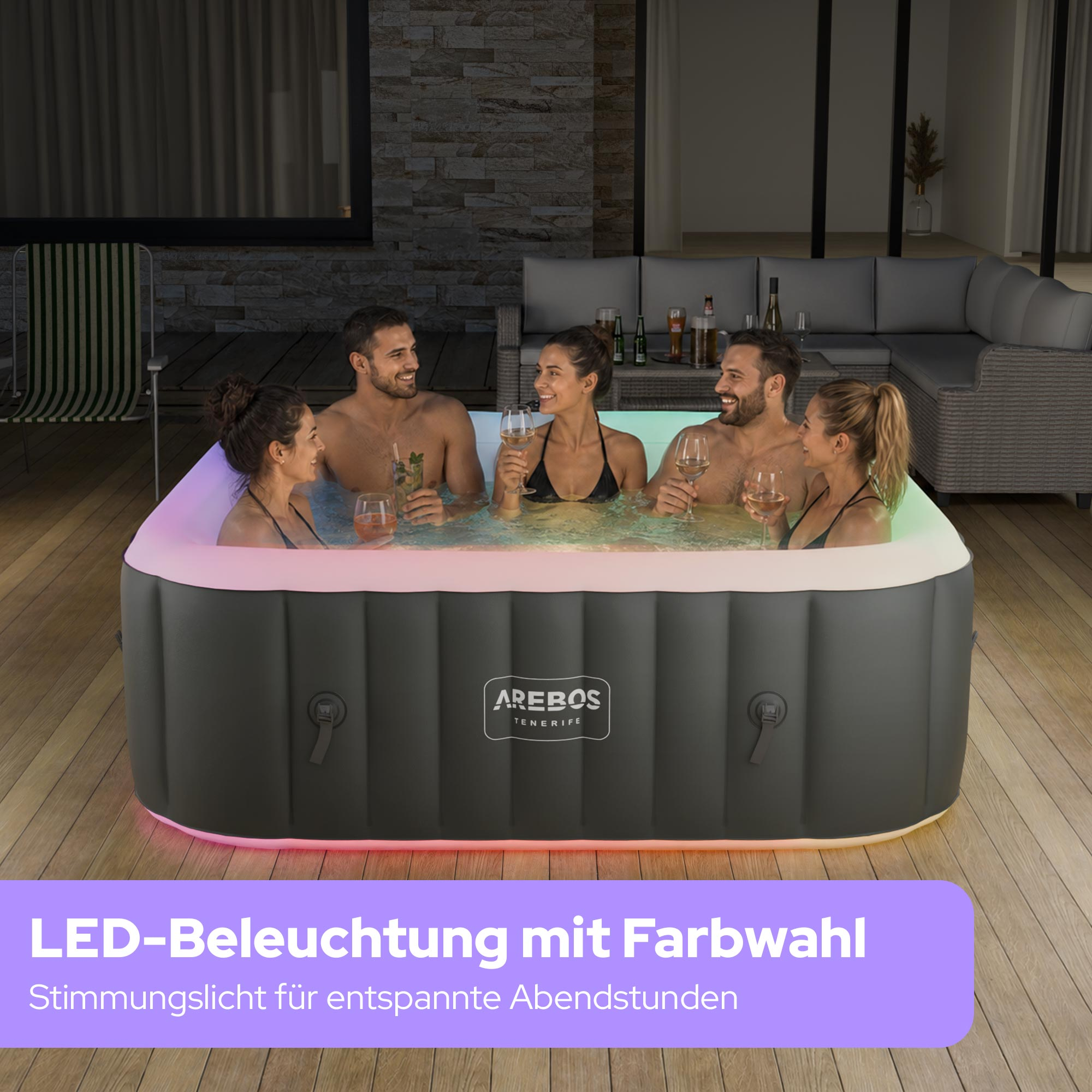 Sechs Personen entspannen sich in einem beleuchteten Whirlpool auf einer Holzterrasse.