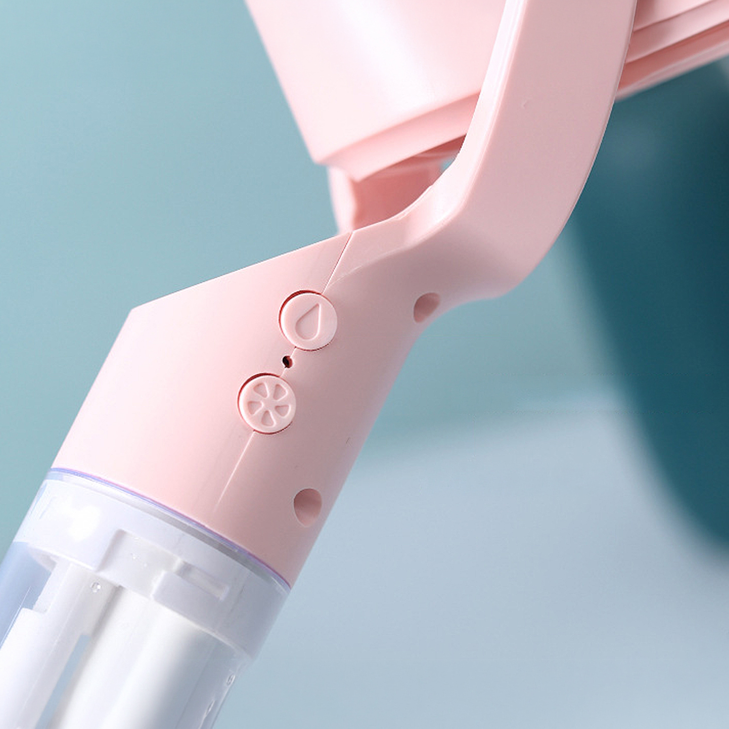 Primer plano de un dispositivo rosa con botones y un recipiente transparente.