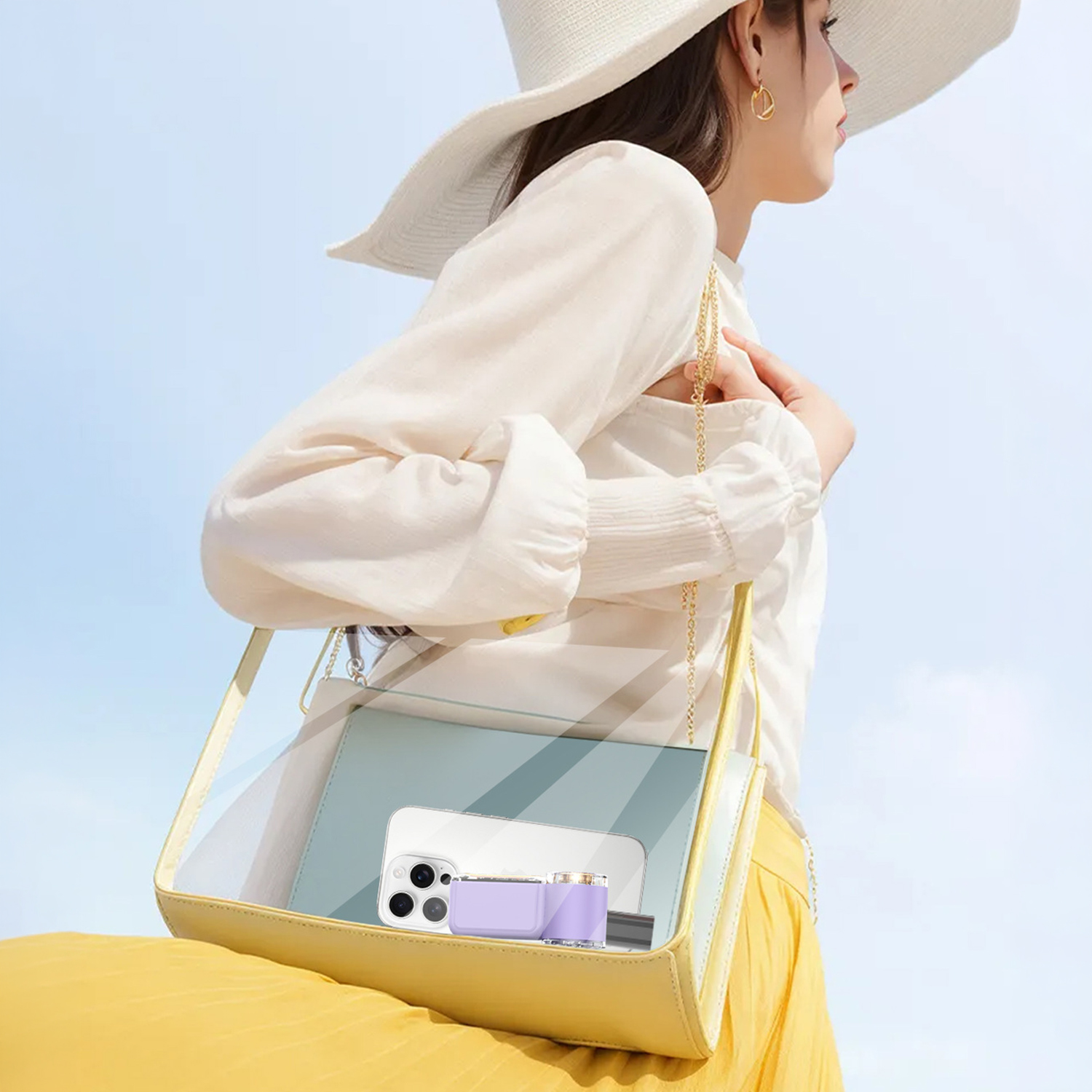 Mujer con sombrero y blusa blancos lleva bolso amarillo con teléfono y cartera.
