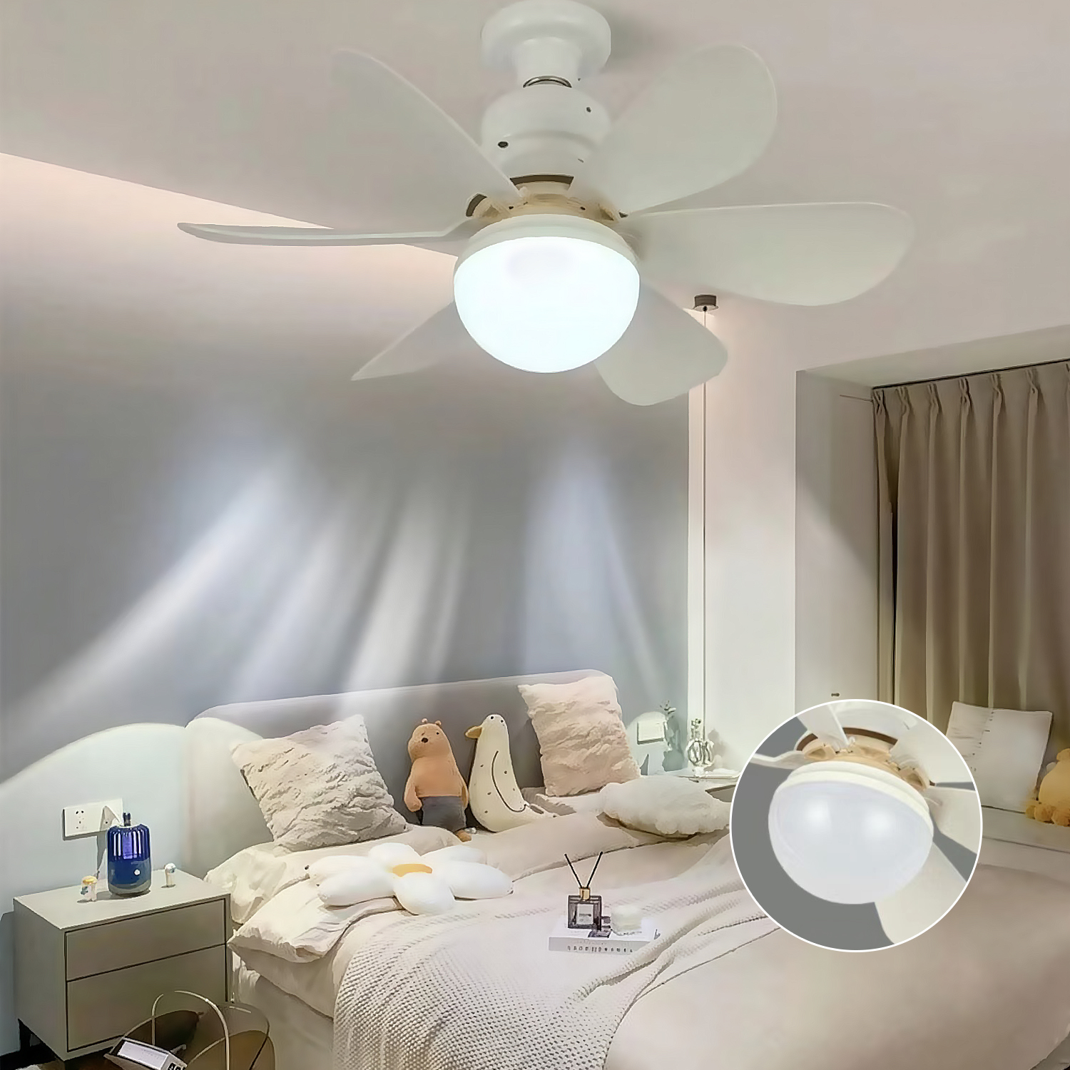 Un ventilador de techo blanco con una lámpara cuelga sobre una cama con almohadas de felpa y animales de peluche en un dormitorio.