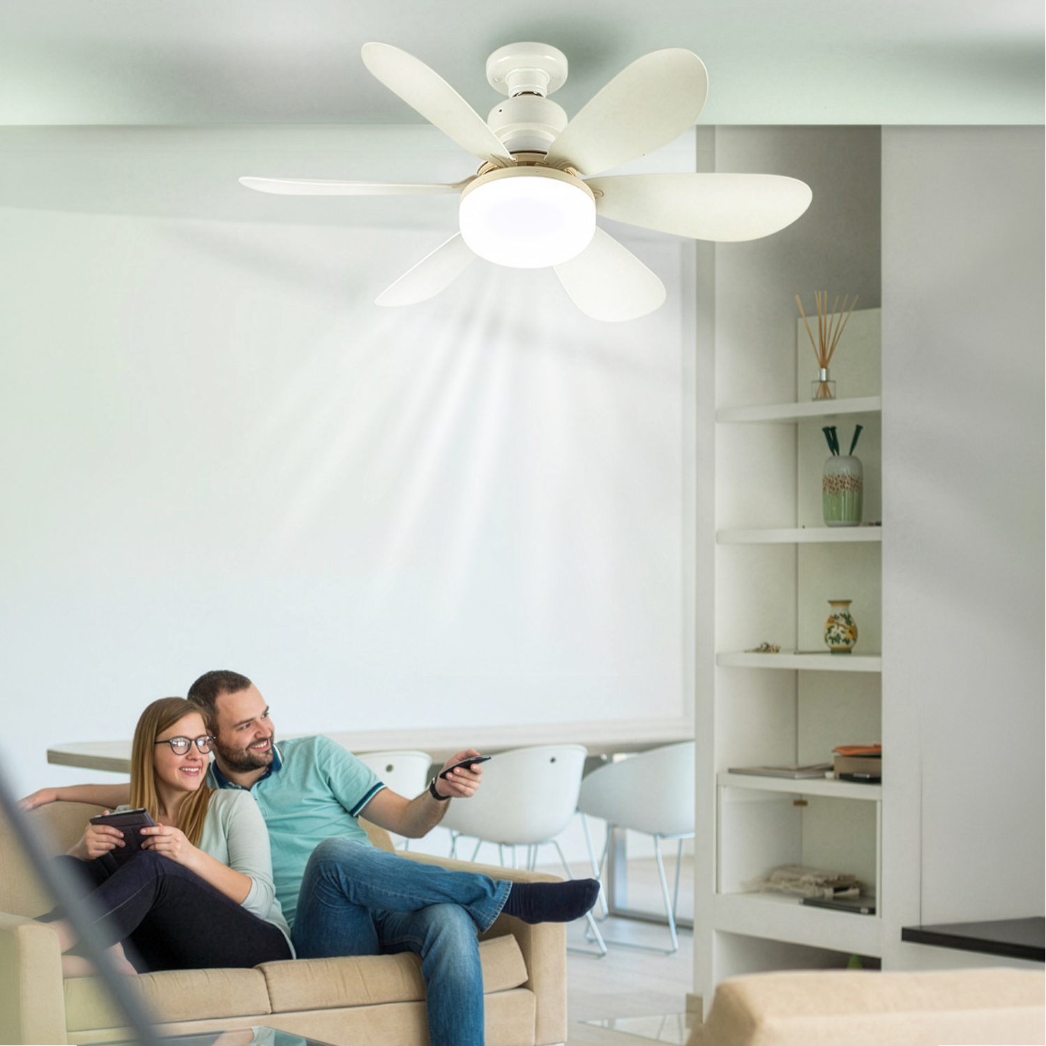 Una pareja se relaja en un sofá mientras un ventilador de techo circula aire.