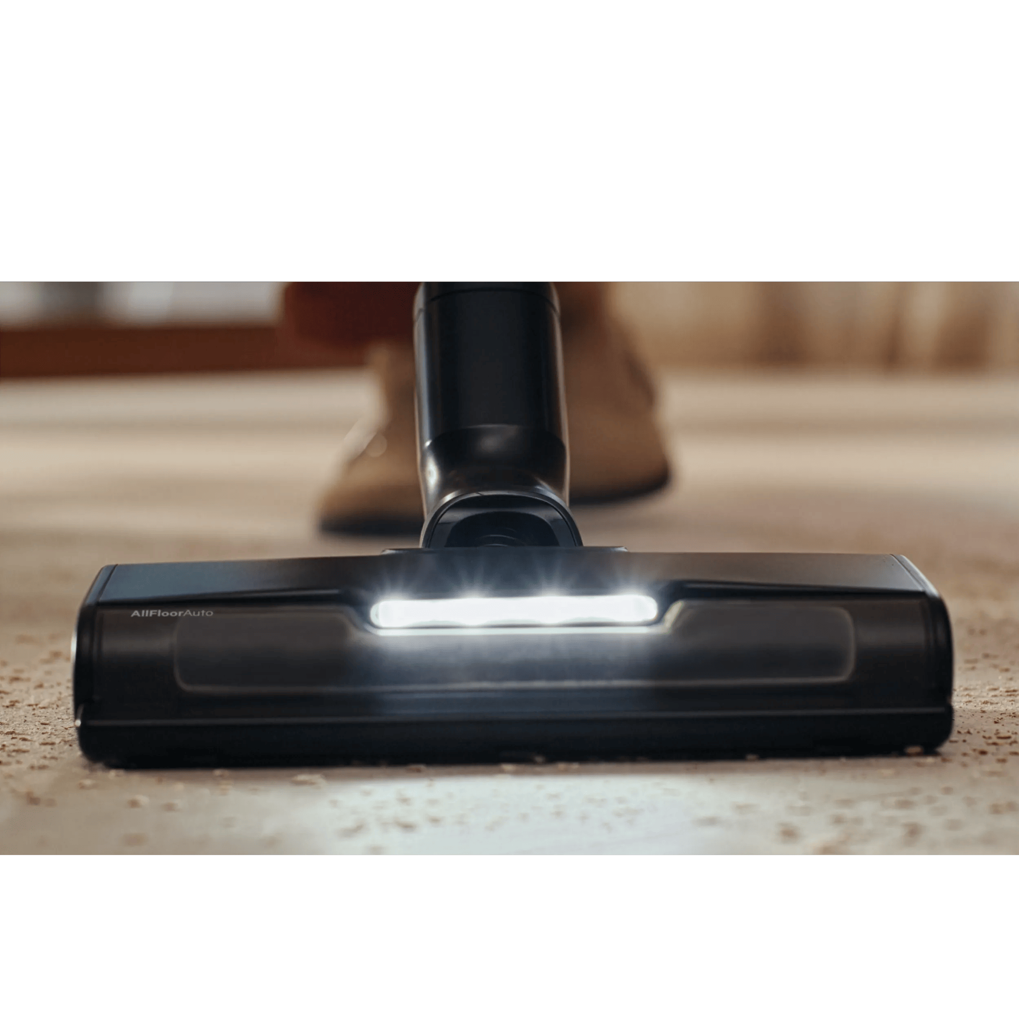 Ugello aspirapolvere si illumina su tappeto con briciole.