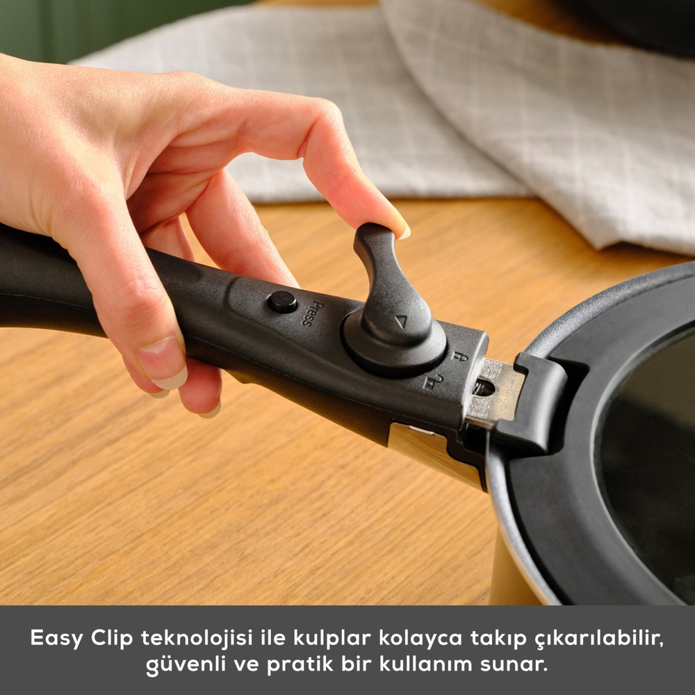 Bir el, tencereye takmak için tutamağın kolunu bastırıyor.