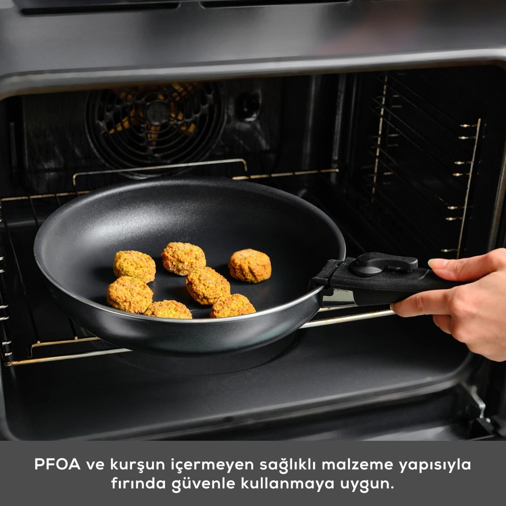Bir el fırının içinde köfteli bir tava tutuyor.