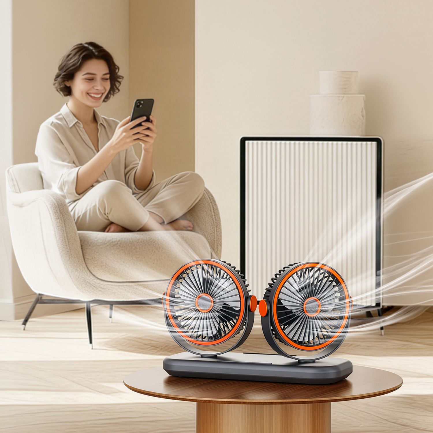 Una mujer sentada mira su teléfono, cerca de un ventilador doble.