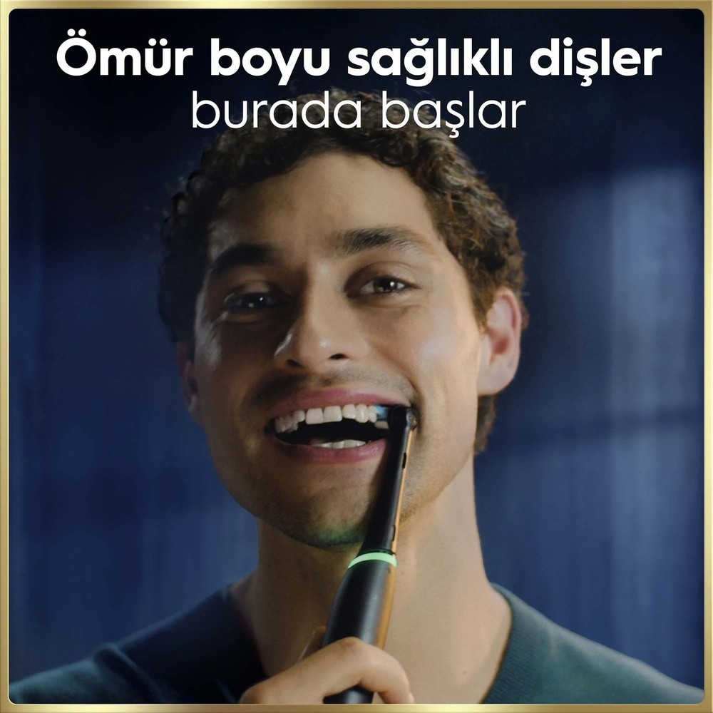 Erkek, elektrikli diş fırçasıyla dişlerini fırçalıyor, yakın çekim.