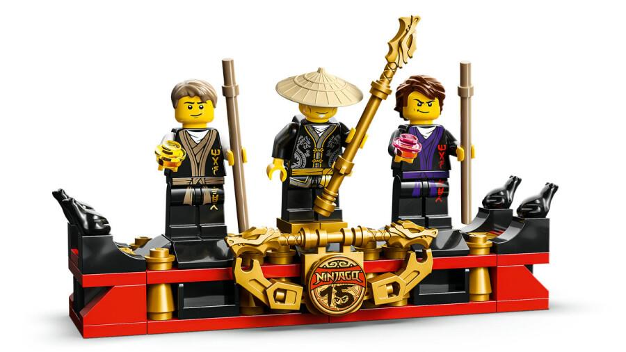 Trzy figurki Ninjago stoją na czerwono-czarnej platformie ze złotymi akcentami.