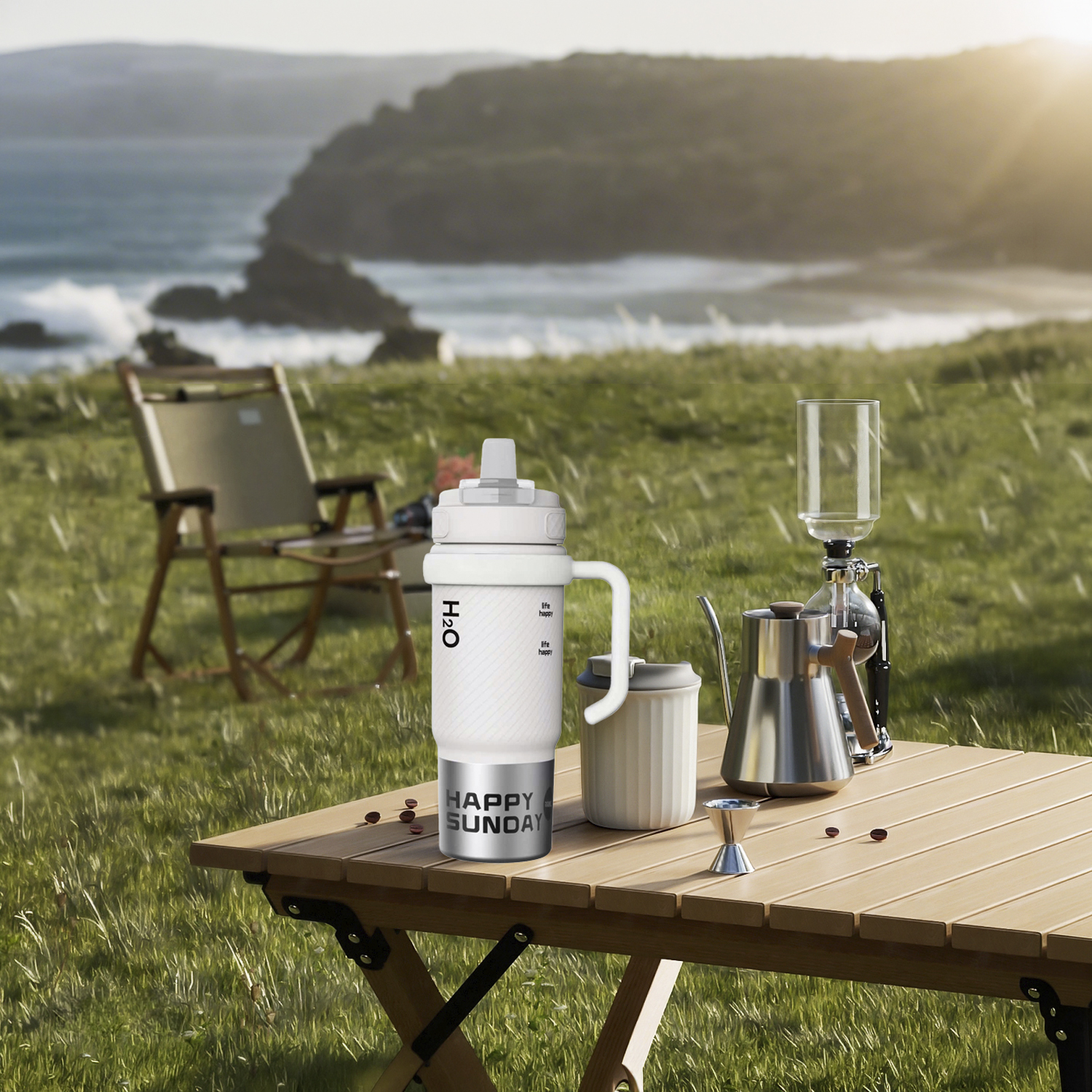 Montaje de café al aire libre en una mesa con botella de agua, tetera y sifón junto al mar.