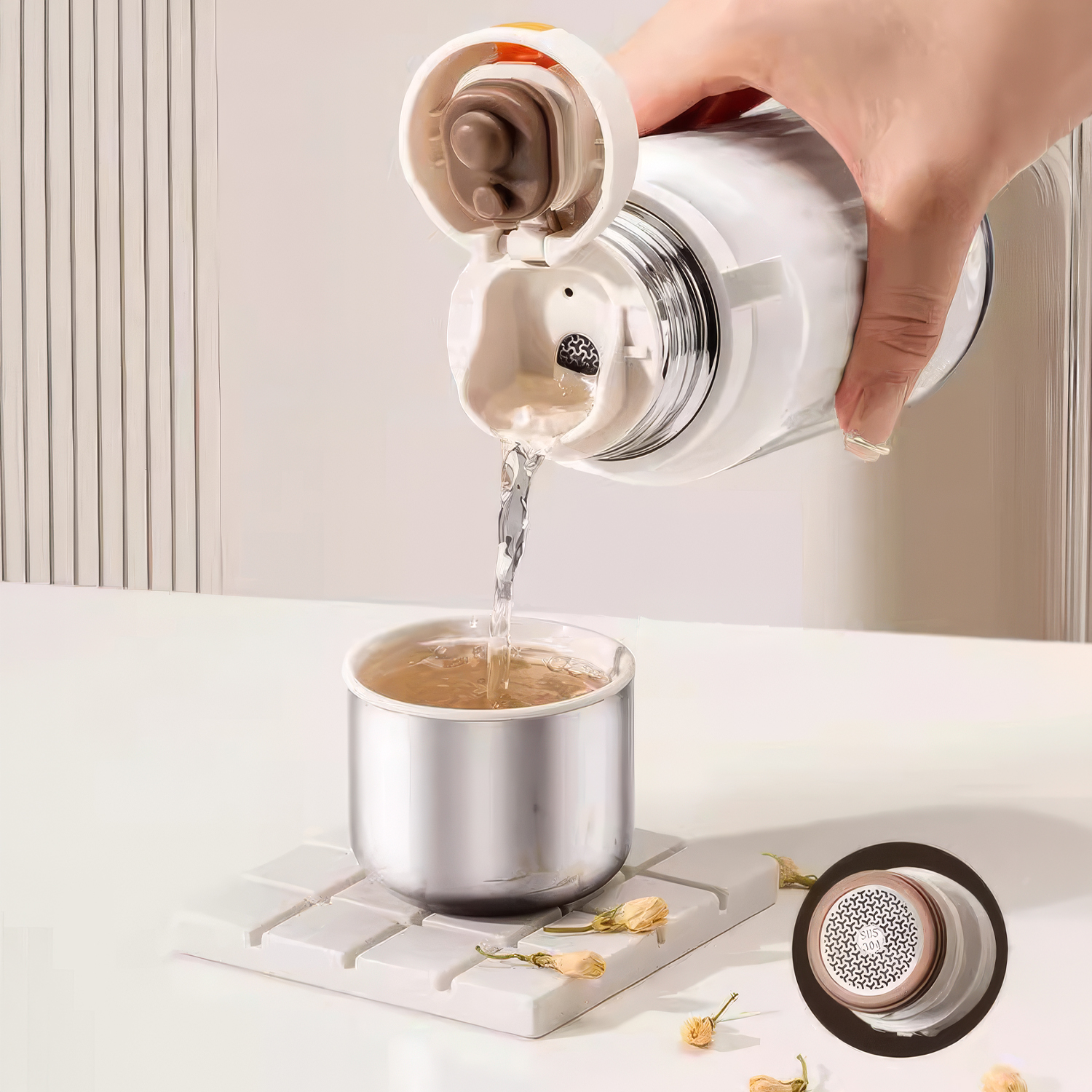 Se vierte agua de un termo blanco en una taza de metal.