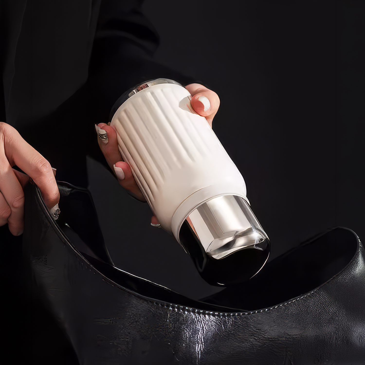 Una persona coloca una botella blanca acanalada en un bolso negro.