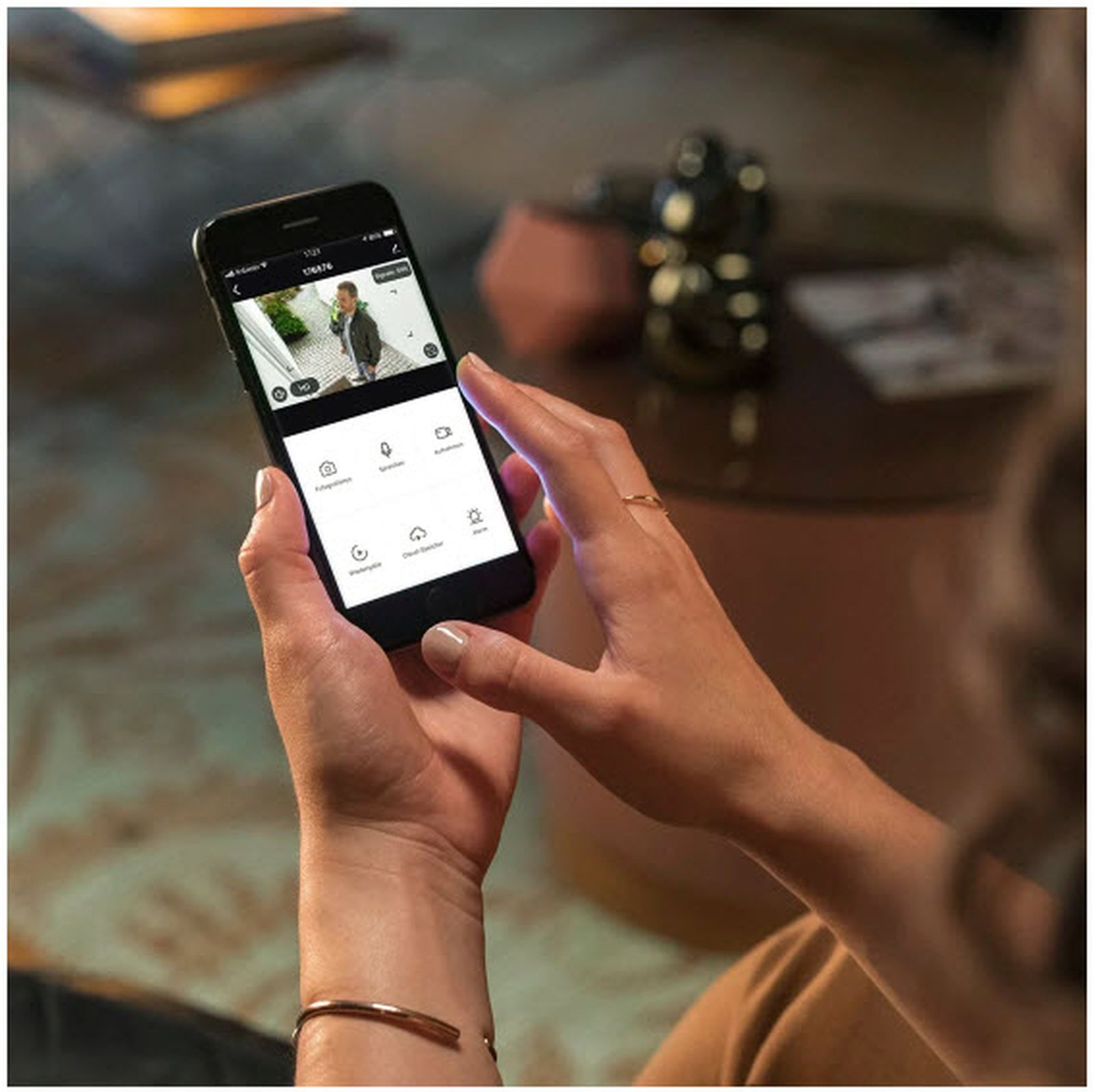 Una persona tiene uno smartphone che mostra un'app di videocamera di sicurezza.