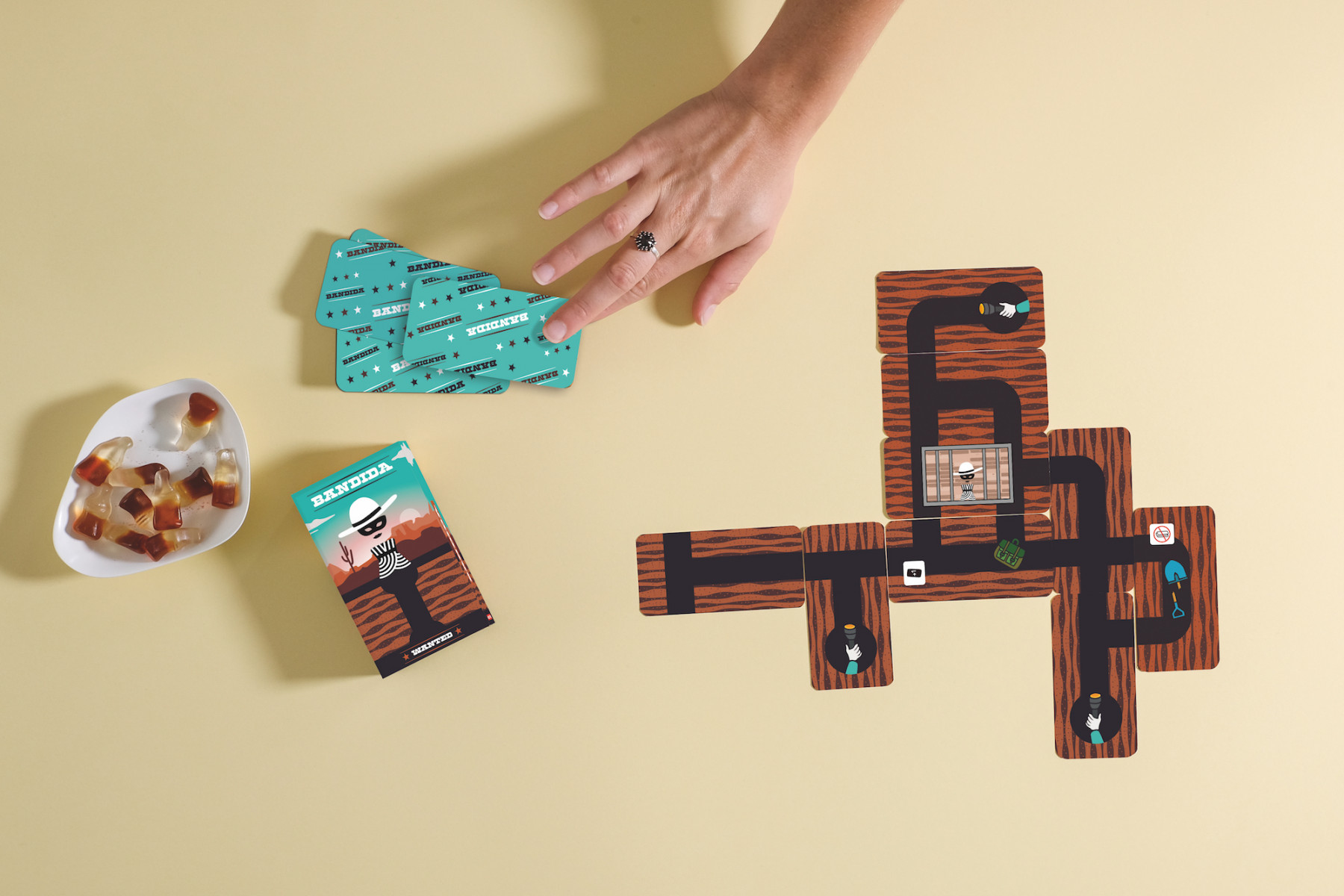Un tablero de juego con patrón de madera, dulces y cartas.