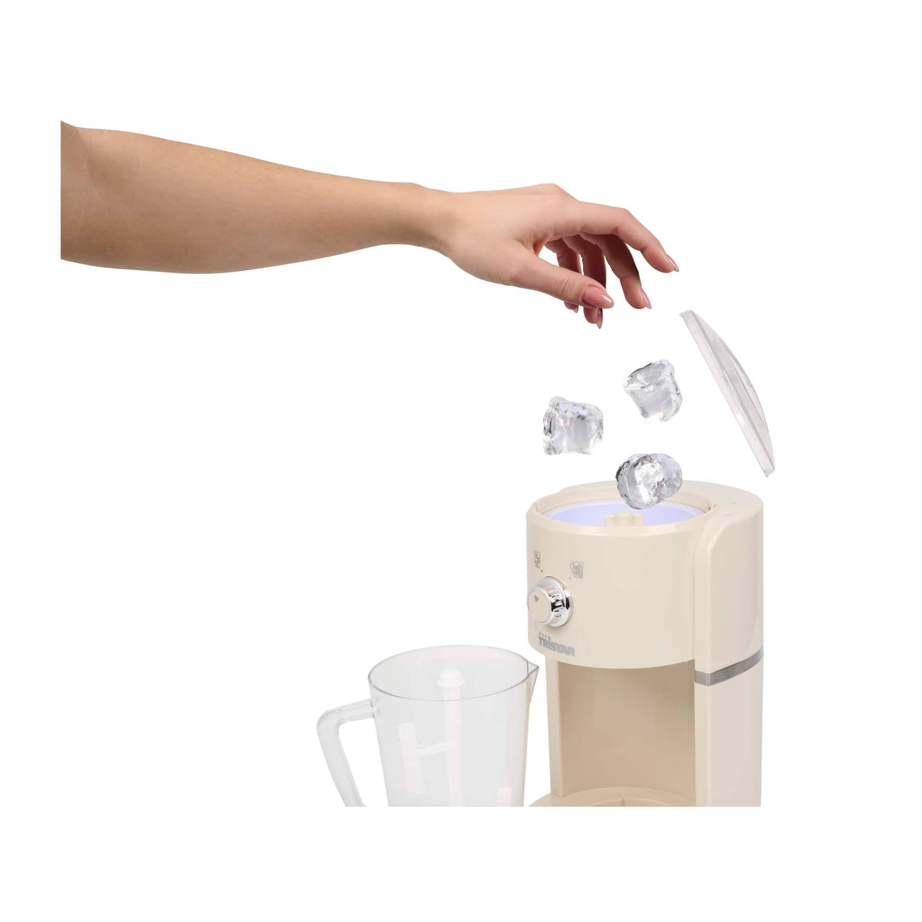 Una mano lascia cadere cubetti di ghiaccio in una macchina color crema accanto a una caraffa.