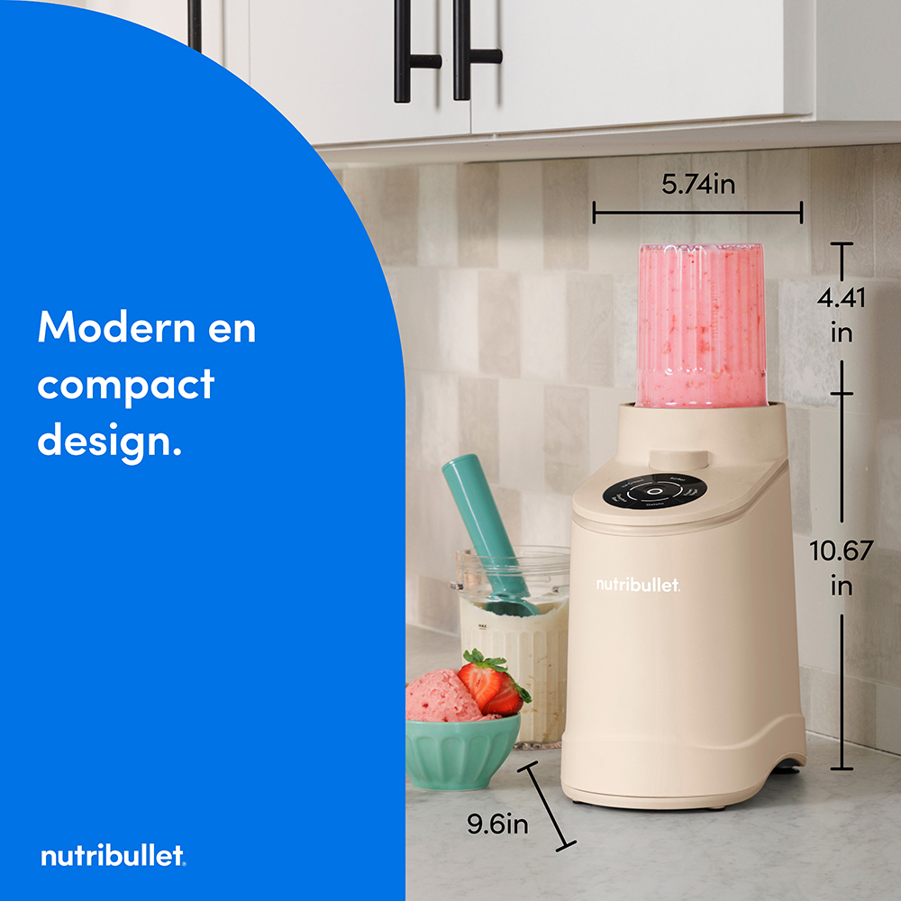 Un mixeur Nutribullet beige avec un smoothie rose dans son gobelet, à côté d'un bol de crème glacée.