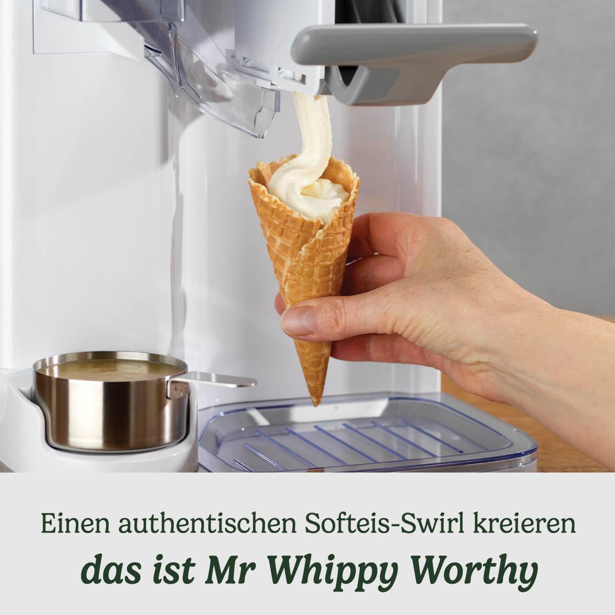 Eine Hand füllt Softeis in eine Waffel aus einem Eisbereiter.