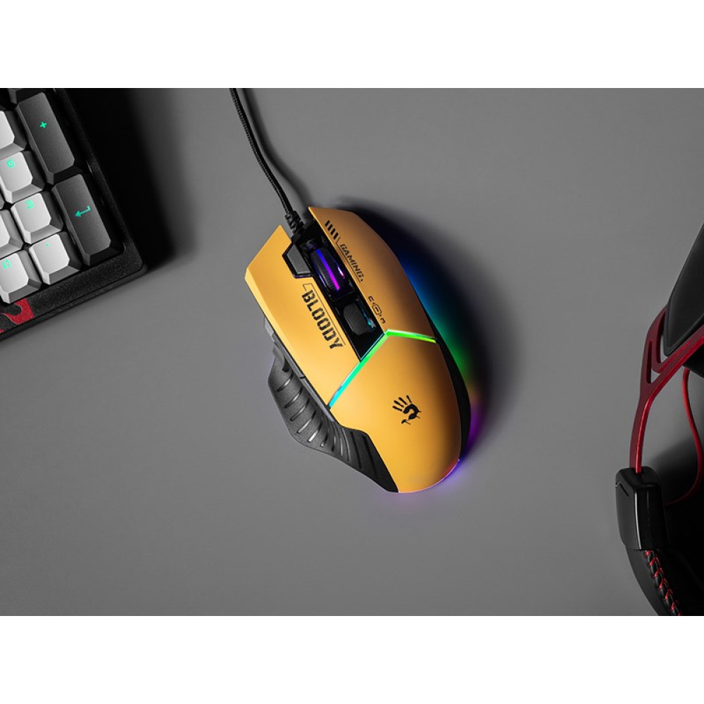 Żółta mysz gamingowa z oświetleniem RGB, obok klawiatury i słuchawek.