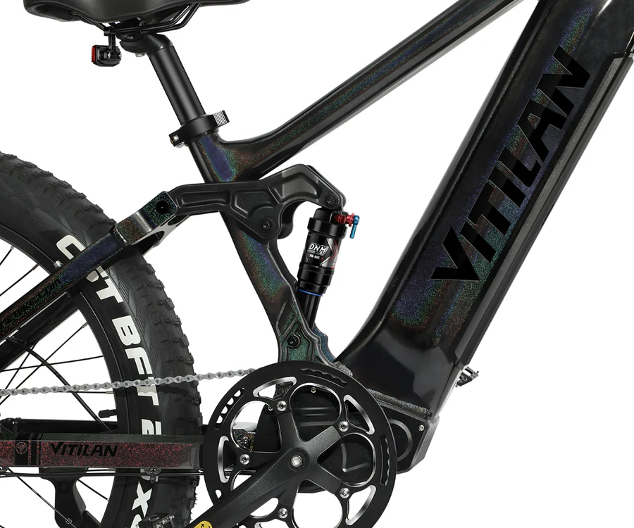 Nahaufnahme eines schwarzen E-Bikes mit schillernden Details, Fokus auf den Rahmen und die Federung.