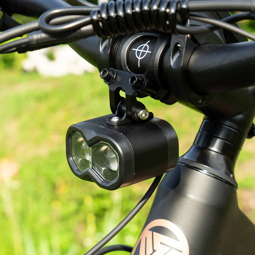 Doppelscheinwerfer an einem Fahrradlenker mit grünem Hintergrund.