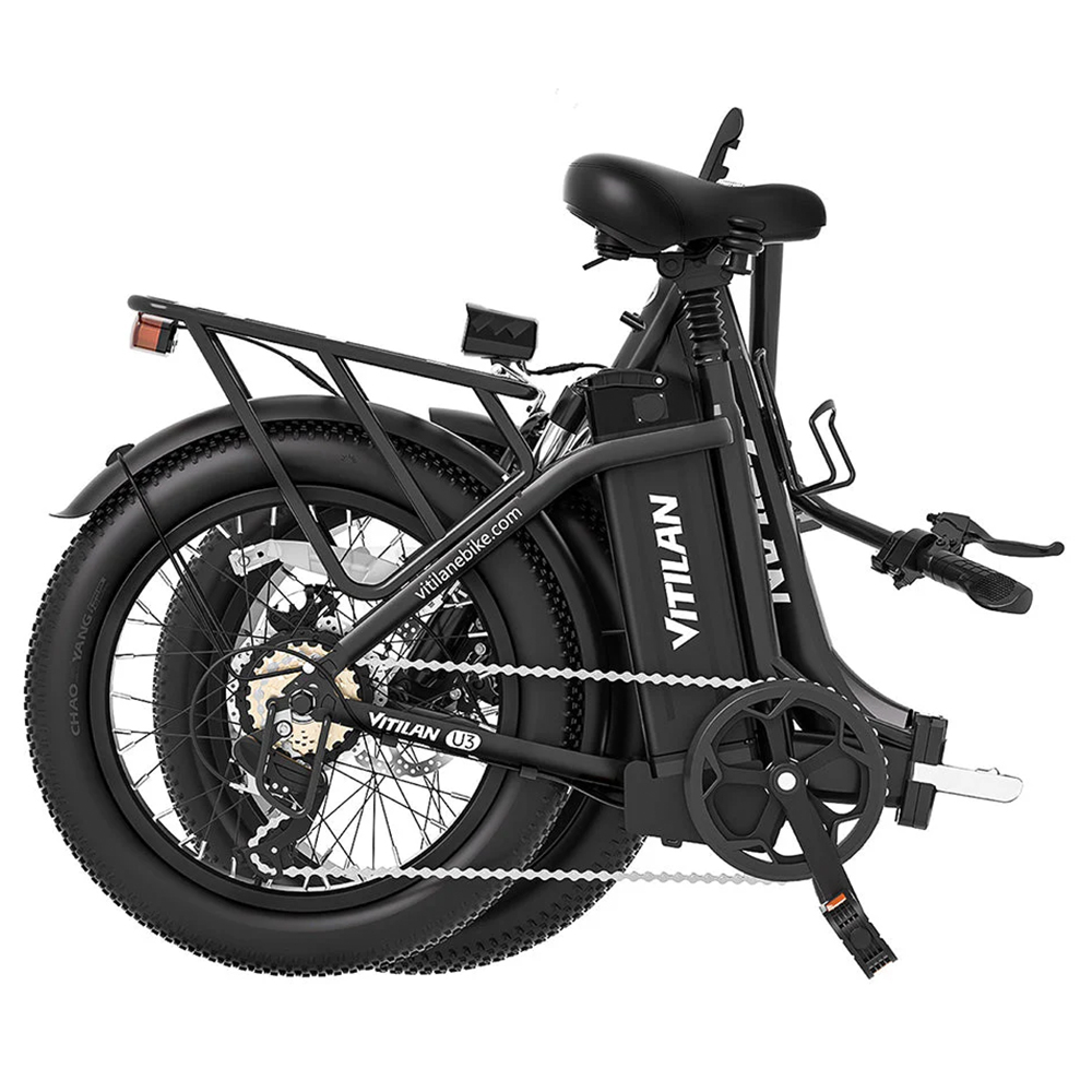 Schwarzes faltbares E-Bike mit Gepäckträger, breiten Reifen und Kettenantrieb.