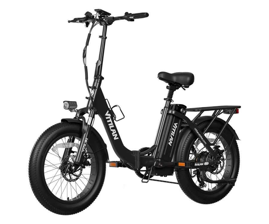 Ein schwarzes faltbares E-Bike mit fetten Reifen, Gepäckträger und Scheinwerfer.