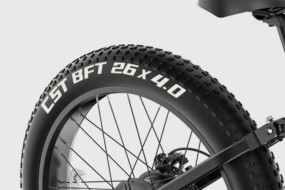 Nahaufnahme eines Fatbike-Reifens mit der Aufschrift "CST BFT 26 X 4.0" und stolligem Profil.