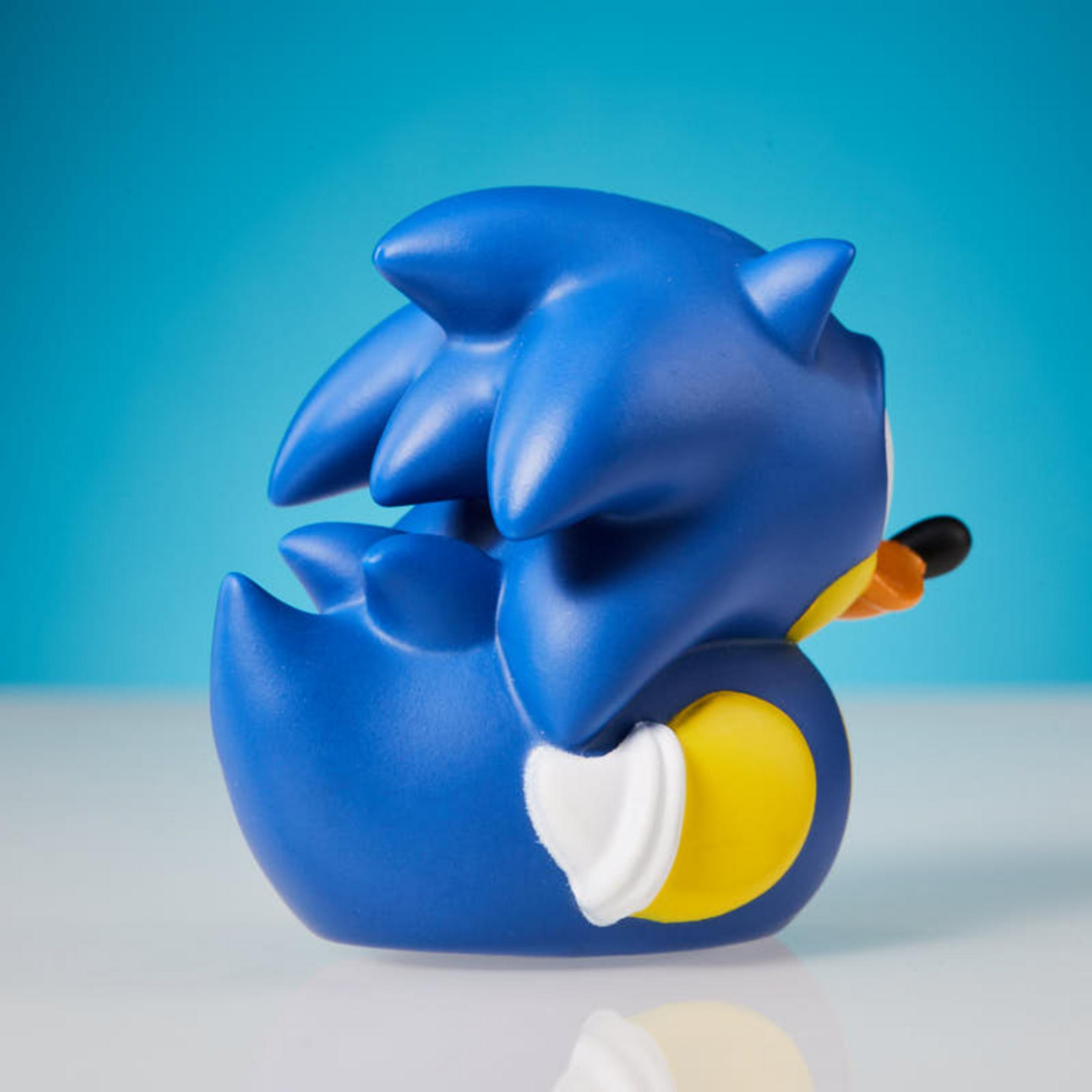 Eine blaue Sonic-Gummiente sitzt auf einer weißen Oberfläche vor blauem Hintergrund.