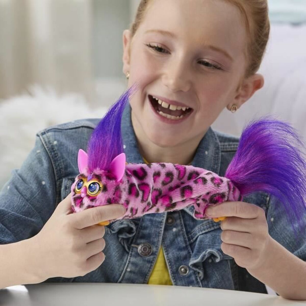 Ein Mädchen mit einem pinken Plüschtier mit Leopardenmuster und lila Haaren.