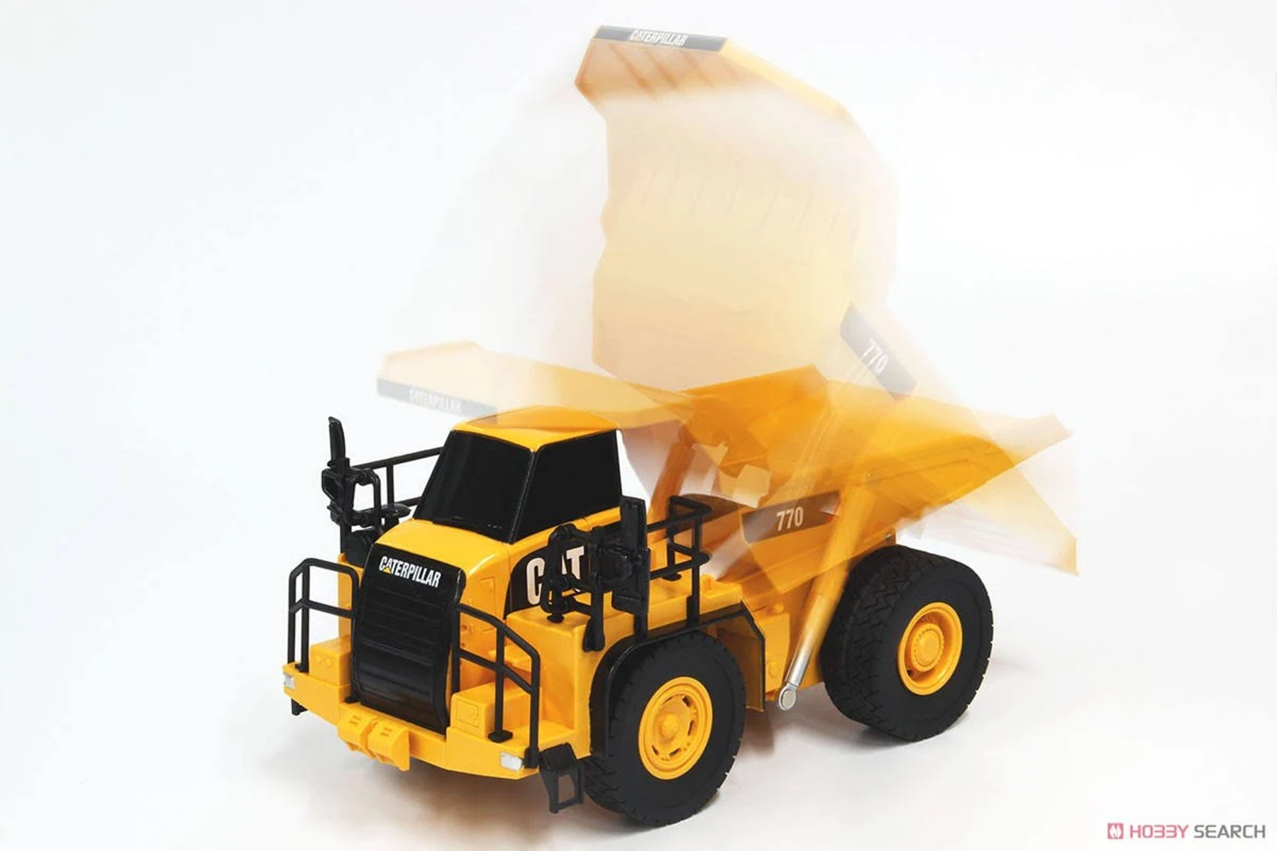 Ein gelber Spielzeug-Muldenkipper mit "Caterpillar"-Logo auf schwarzem Hintergrund.