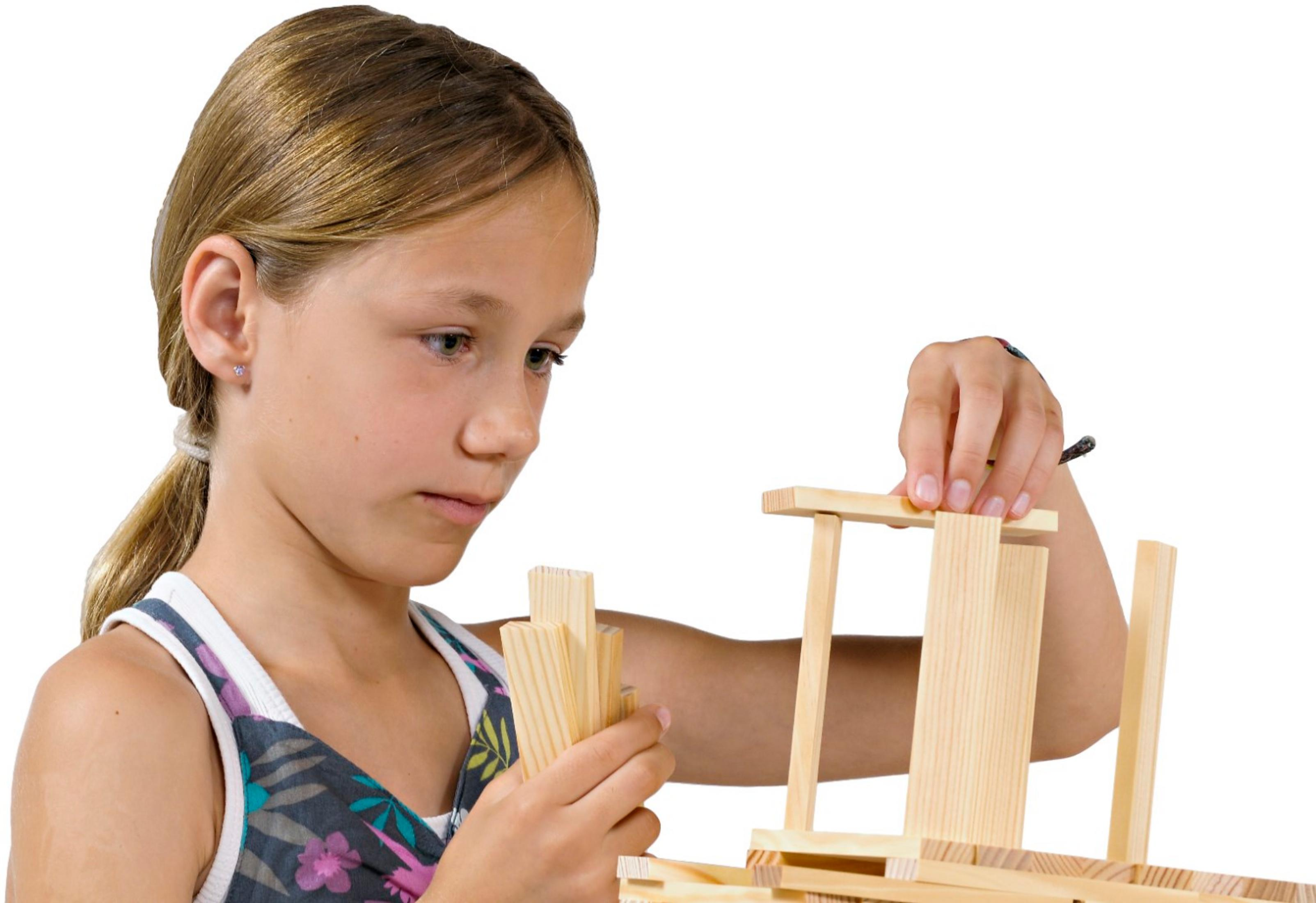Ein junges Mädchen baut mit Holzbausteinen.