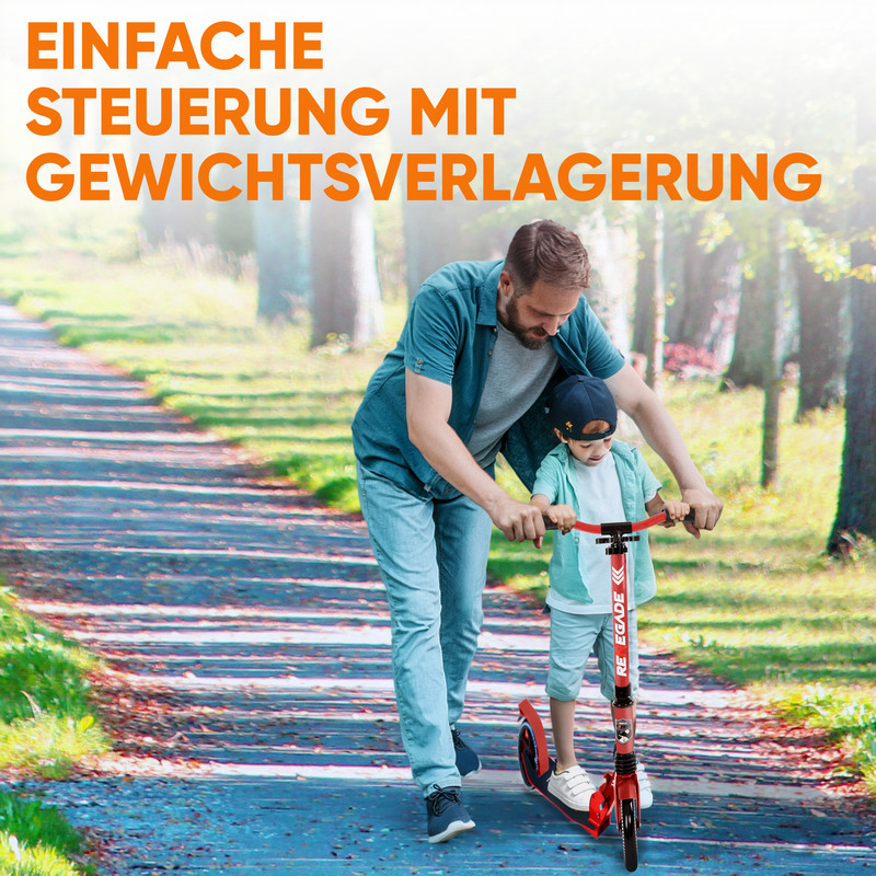 Vater hilft Sohn auf rotem Roller auf einem Weg im Park.