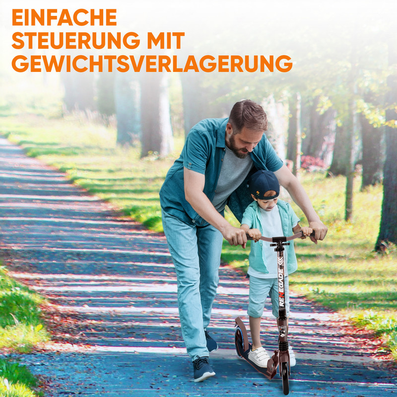 Vater hilft Sohn auf Roller auf einem Weg im Park.