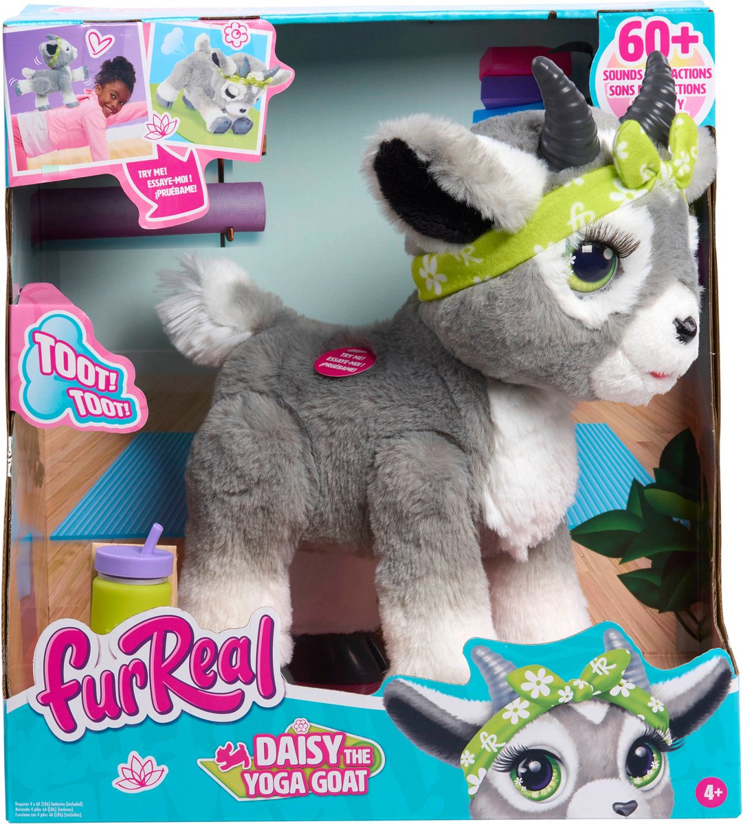 Un peluche de cabra gris llamado Daisy, la Cabra de Yoga, en una caja. Lleva una diadema verde.