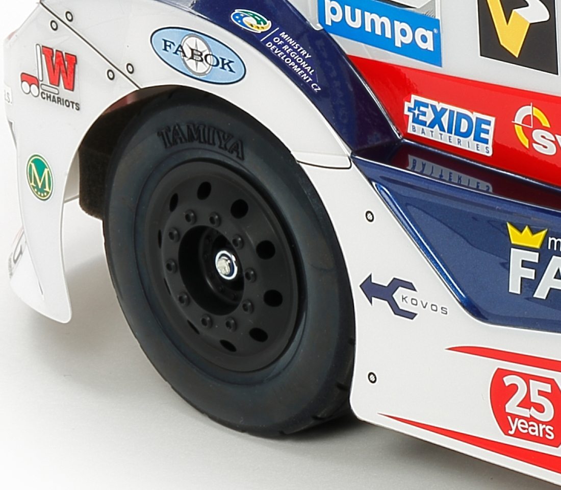 Nahaufnahme eines Rennwagens mit dem TAMIYA-Rad und verschiedenen Logos wie EXIDE.