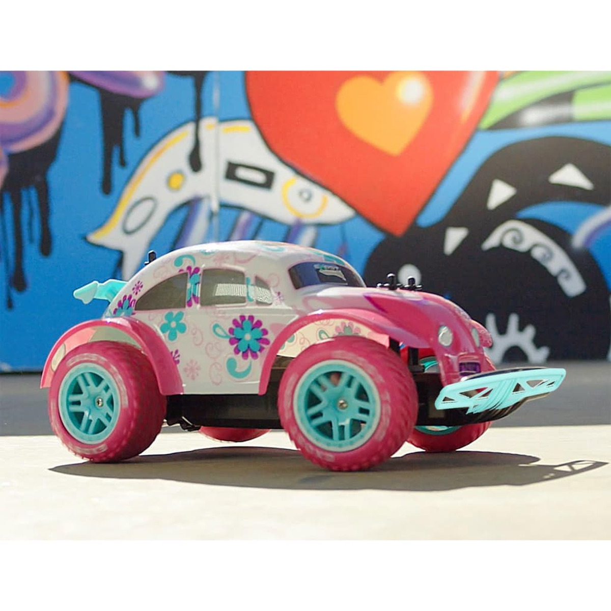 Ein Spielzeugauto im VW Käfer-Stil mit Blumenmuster auf weißem Hintergrund.