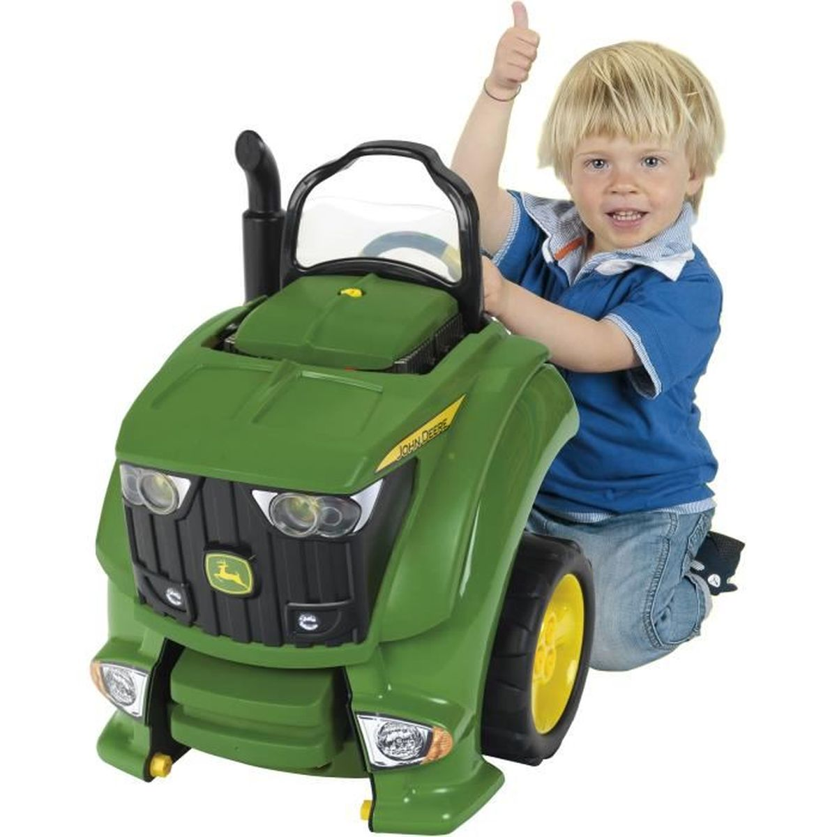 Un niño rubio da pulgares arriba junto a un tractor de juguete verde.