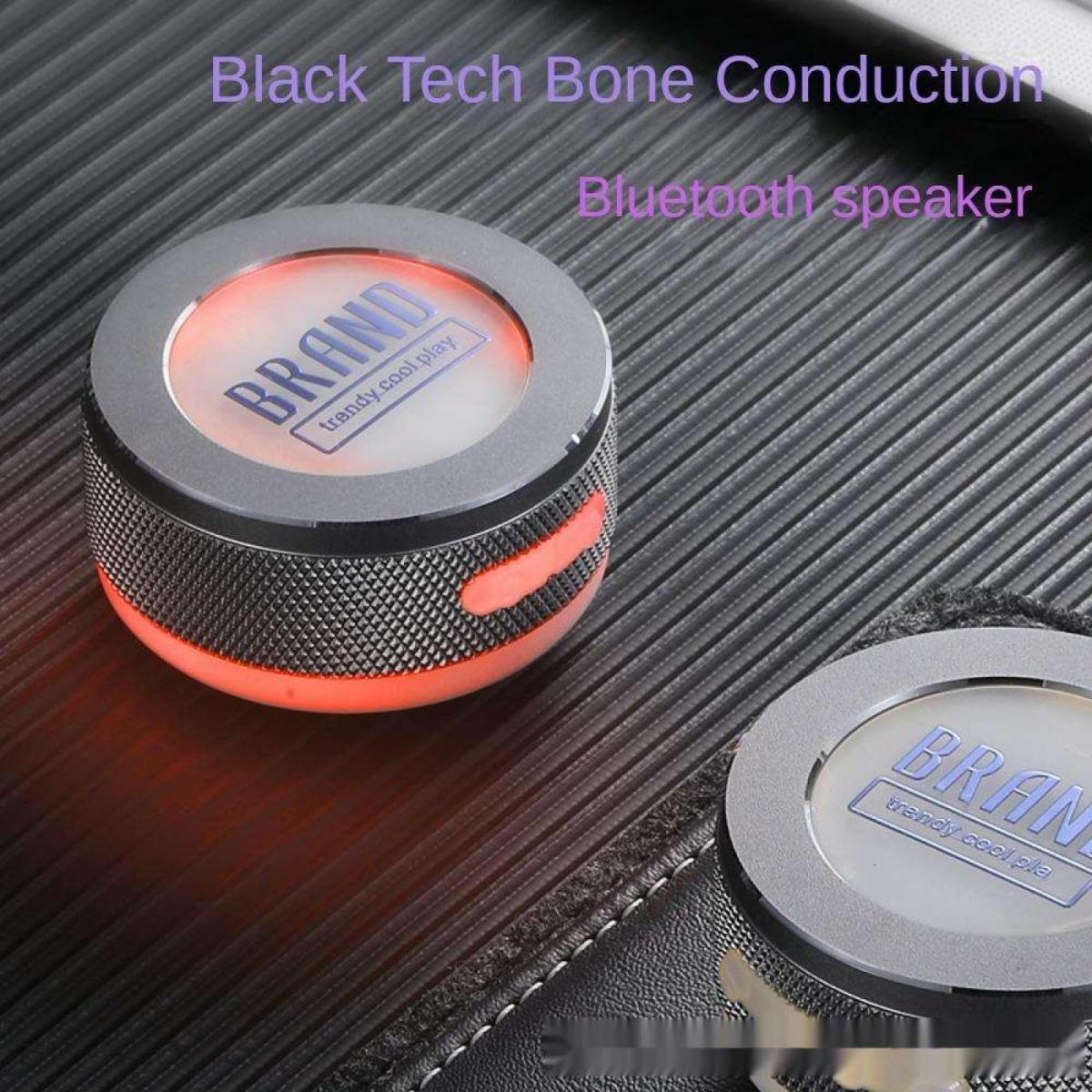 Ein runder, silberner Bluetooth-Lautsprecher mit roter Beleuchtung steht auf einer gerippten Oberfläche.