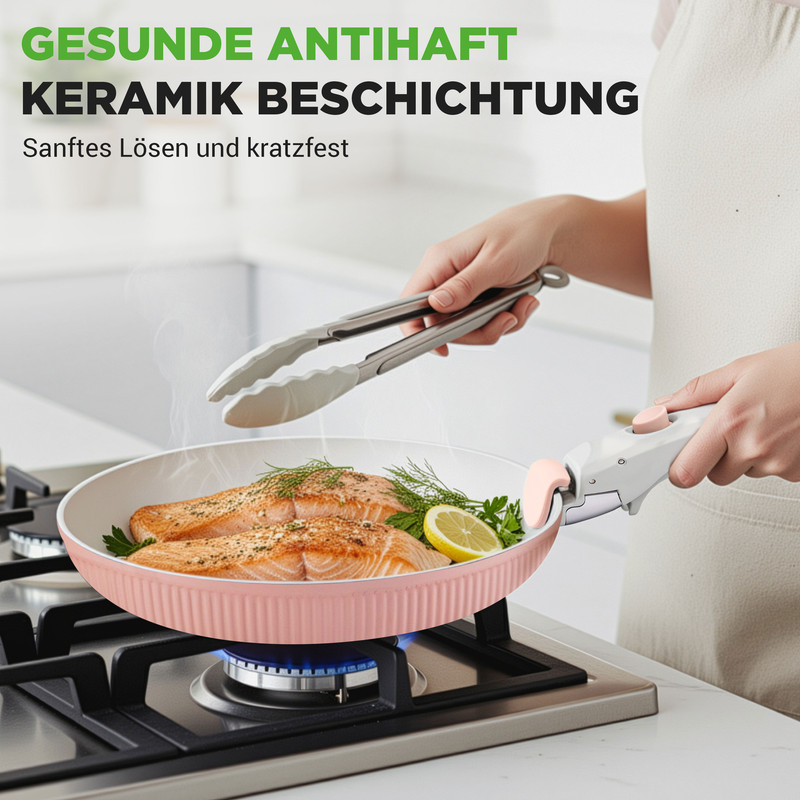 Zwei Lachsfilets werden in einer rosa Pfanne auf einem Gasherd gebraten. Dampf steigt auf.
